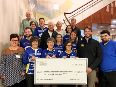 courage ride members presented with a check of 100,000 dollars for cancer research